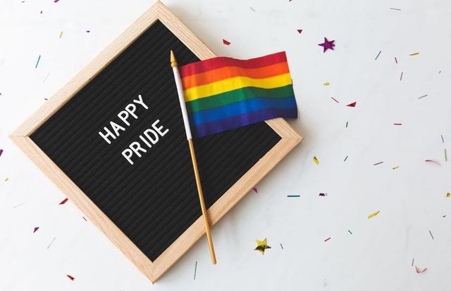 pride flag on top of a little sign reading "happy pride"