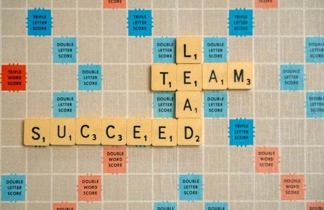 scrabble tiles spelling team, lead, and succeed