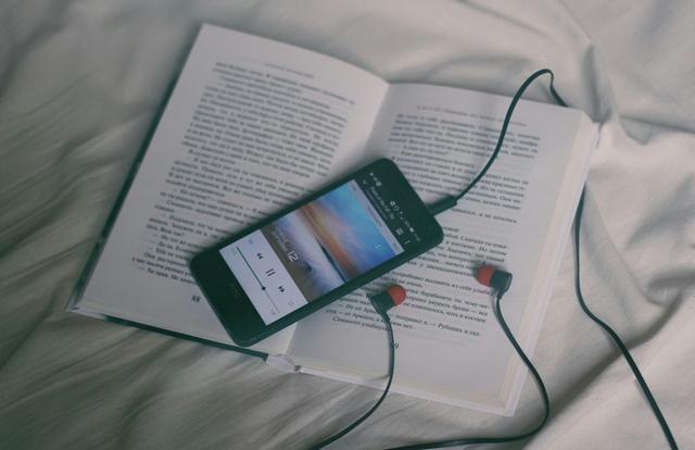 mp3 player and headphones on top of a book