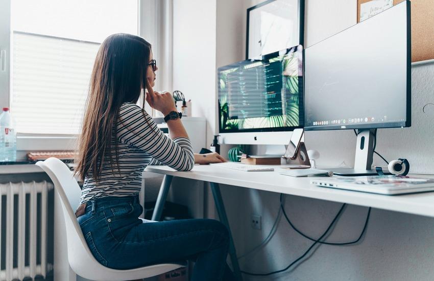 Woman working at a desk in front of a computer screen